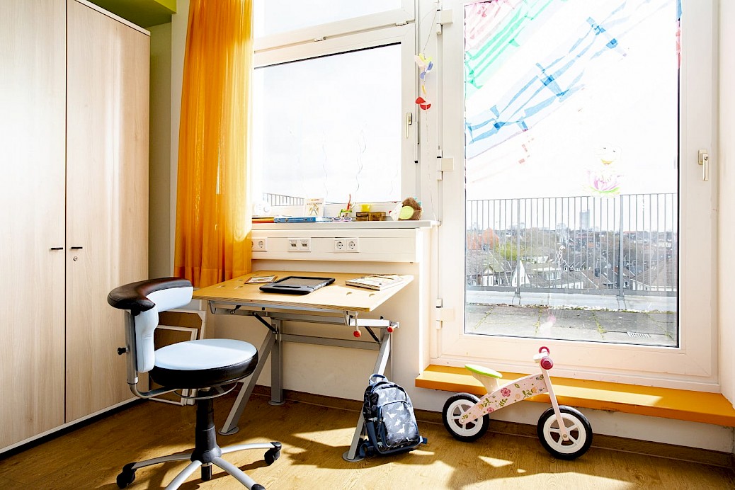 Patientenzimmer mit Schreibtisch und Laufrad