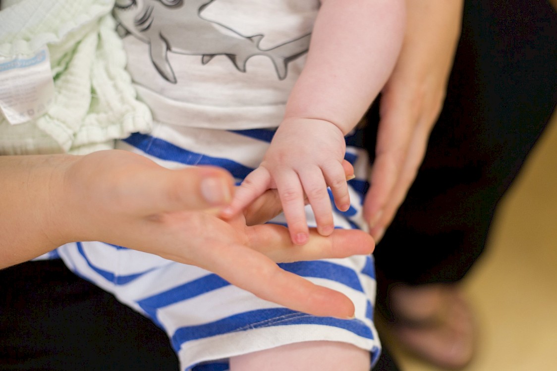 Erwachsenenhand hält Hand eines Babys
